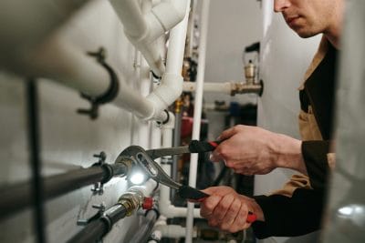 Technician inspecting commercial plumbing pipes in Rohnert Park